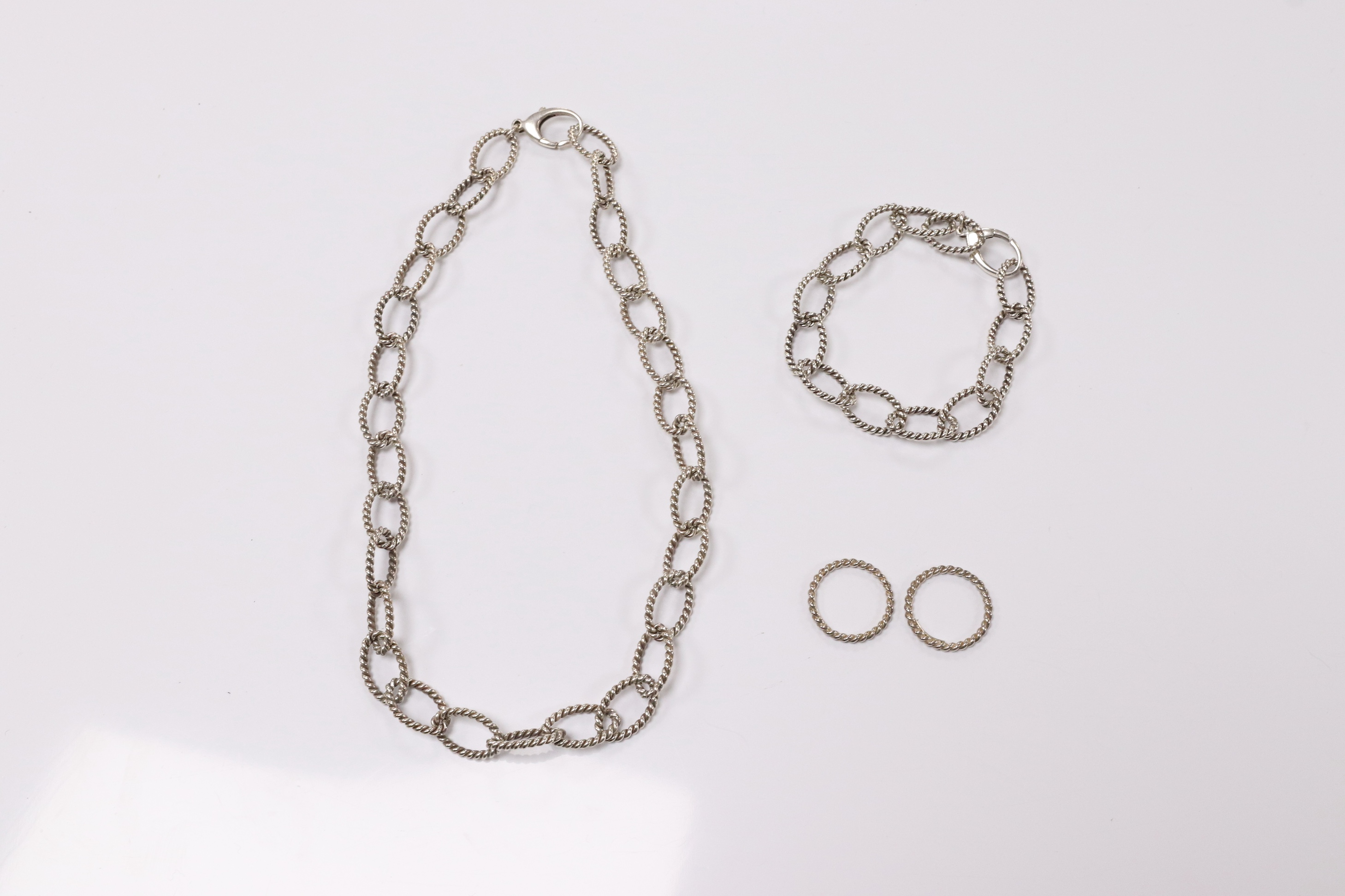 A modern Italian Tiffany & Co 925 suite of jewellery, of rope twist design, comprising a necklace, 42cm, bracelet, 18cm and two rings, size O/P and O. Condition - fair to good